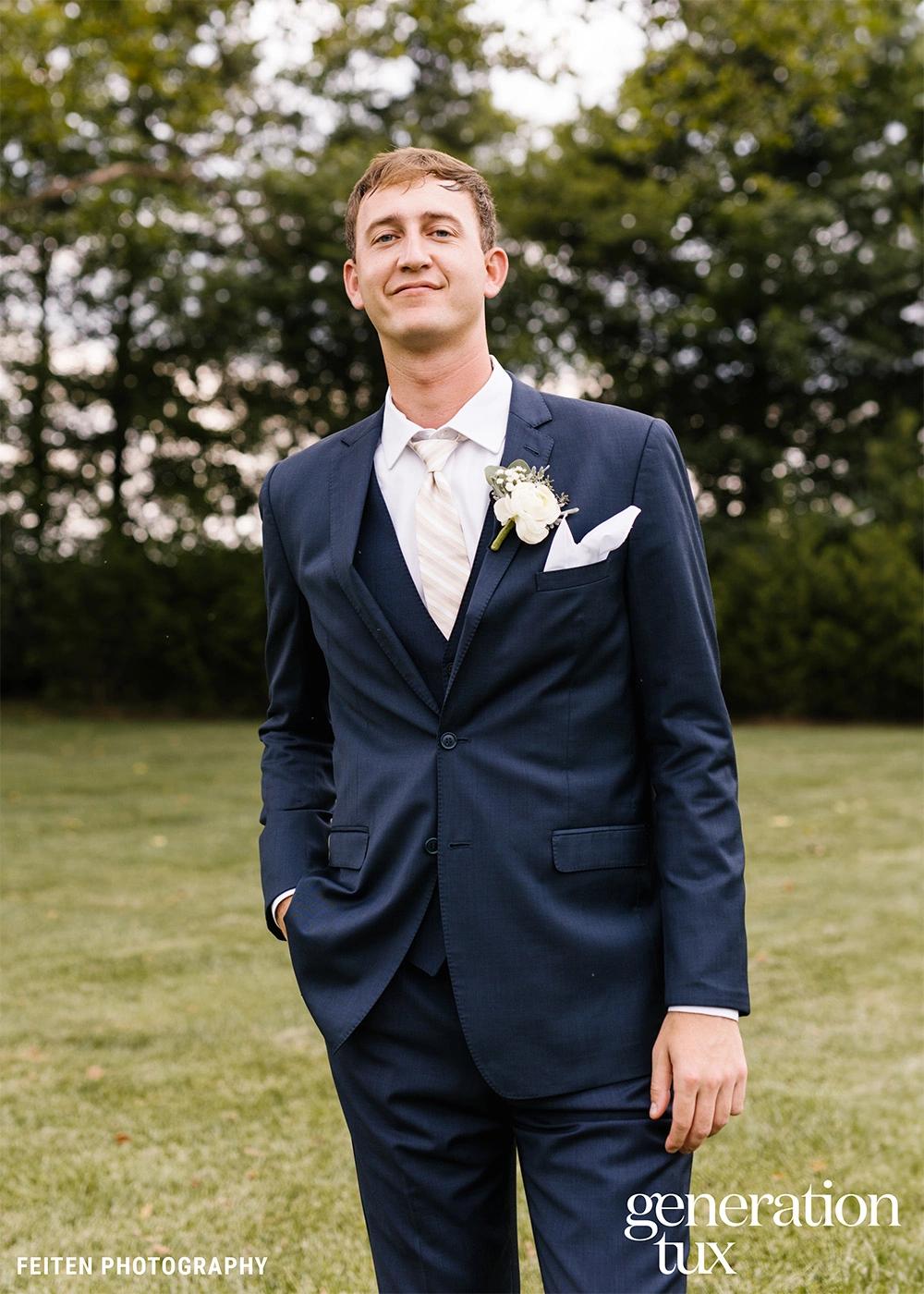 model in dark blue tux